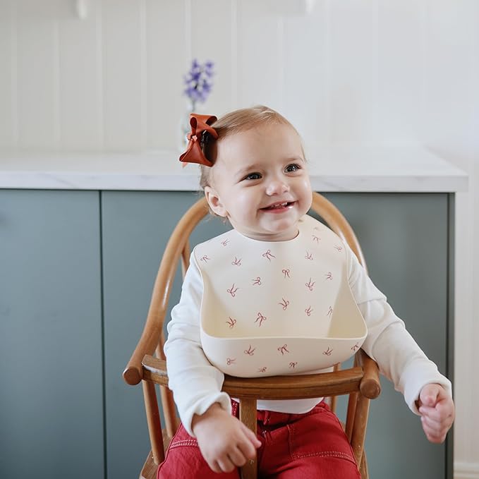 mushie Silicone Baby Bib | Adjustable Fit Waterproof Bibs (Bows)